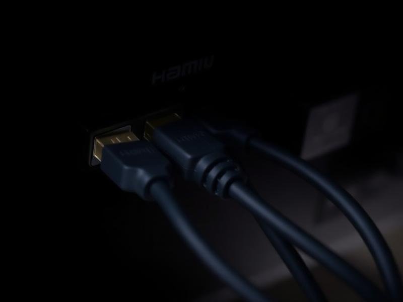 HDMI cables plugged into the back panel of a television